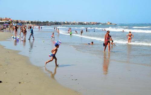eine Gruppe von Menschen, die am Strand spazieren gehen in der Unterkunft Higuericas Beach Apartment in Pilar de la Horadada