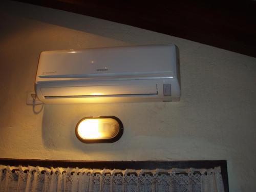 a light on a wall next to a room at Chalé no Centro de Canela in Canela