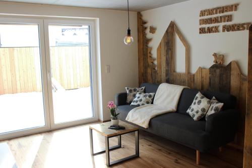 a living room with a couch and a table at Apartment Monolith Black Forest in Schonach