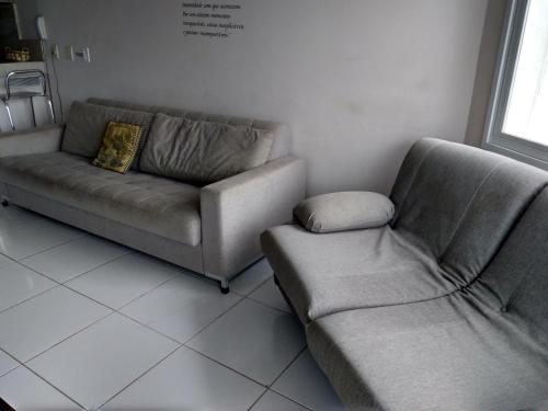 a living room with a couch and a chair at Estrela do Mar in Florianópolis