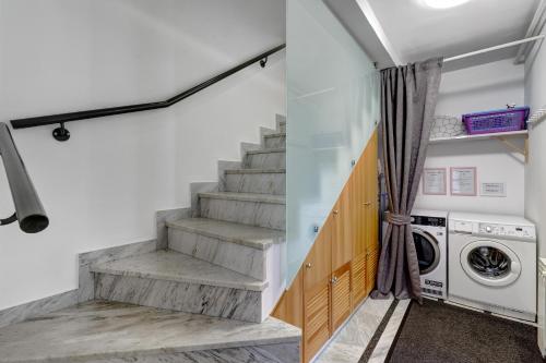 a laundry room with stairs and a washer and dryer at Apartments Viola in Zagreb