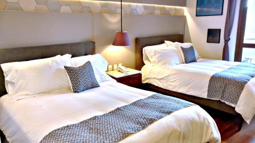 a hotel room with two beds and a lamp at Casa Rosa Gran Hotel Boutique in Puebla