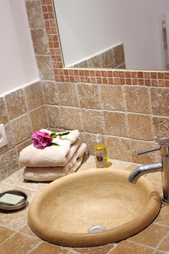 - un lavabo avec une fleur au-dessus dans l'établissement Mini villa Marina Serena, à Porto-Vecchio