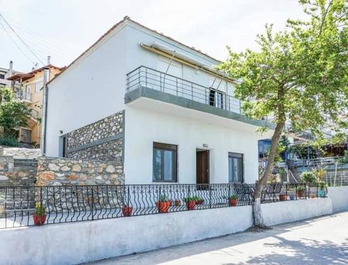 a white house with a fence in front of it at Ilio Socrates in Skala Marion