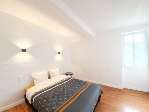 ein Schlafzimmer mit einem Bett mit zwei Kissen und einem Fenster in der Unterkunft Appartement de charme climatisé in Graulhet