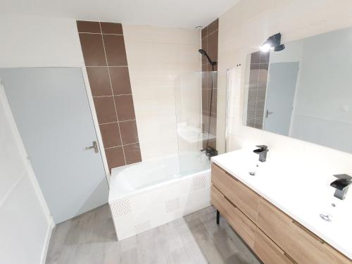 ein weißes Badezimmer mit einer Badewanne und einem Waschbecken in der Unterkunft Appartement de charme climatisé in Graulhet