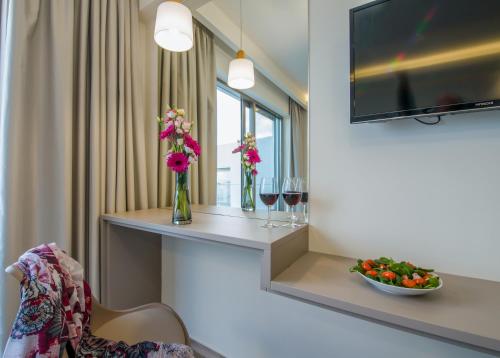 a hotel room with a table with wine glasses and flowers at Incognito Creta Luxury Suites and More in Kolymvari