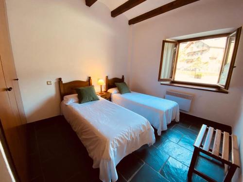 a bedroom with two beds and a window in it at Apartamentos Linsoles in Eriste