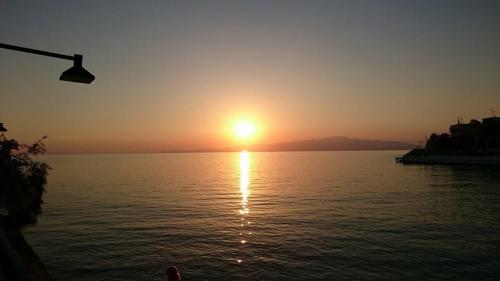 a sunset over a body of water with the sun setting at Ilio Socrates in Skala Marion
