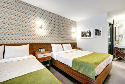 a hotel room with two beds and a bathroom at Hôtel Uville Montréal in Montréal