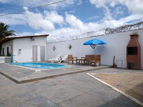 a patio with a table and an umbrella next to a building at Casa de Dona Diana in Barreirinhas