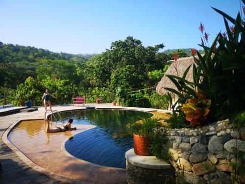 une femme dans un bassin avec une personne dans l'eau dans l'établissement Hostal Mama Tayrona, à Santa Marta