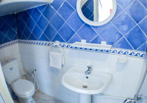 La salle de bains bleue et blanche est pourvue d'un lavabo et de toilettes. dans l'établissement Cosy Triplex in La Marsa - 3 bed 2 Bath, à La Marsa