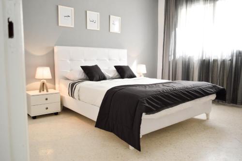 - une chambre avec un lit blanc et une fenêtre dans l'établissement Cosy Triplex in La Marsa - 3 bed 2 Bath, à La Marsa