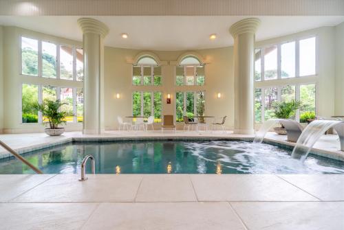 a swimming pool in a house with windows at Hotel Laghetto Siena Gramado in Gramado
