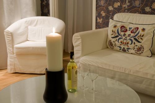 a candle sitting on a table next to a chair with a bottle of wine at Jennys Hotell och Restaurang in Arvika
