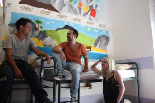 two men and a woman sitting on a bunk bed at Jerusalem Hostel in Jerusalem