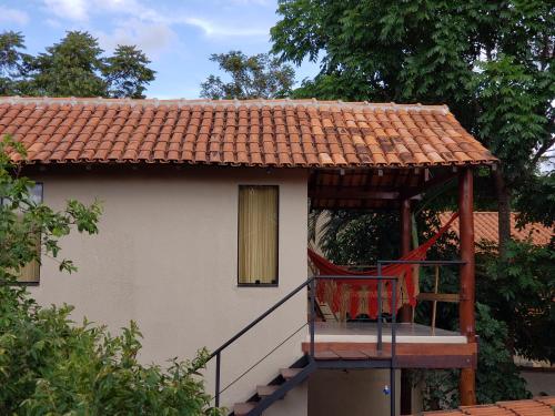 a house with a balcony with a roof at Pousada Beija-Flor in Alto Paraíso de Goiás