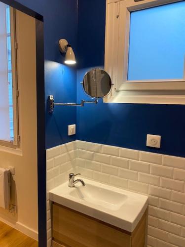 une salle de bain avec un lavabo et un miroir dans l'établissement Joli appartement proche centre avec garage gratuit, à Nantes