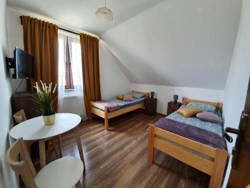 a small room with two beds and a table at Dom Wczasowy u Marci in Tymień