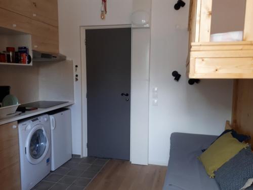 une cuisine avec une machine à laver dans une pièce dans l'établissement La Touques, à Trouville-sur-Mer