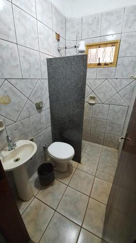 a bathroom with a toilet and a sink at Delta Hotel in Andradina