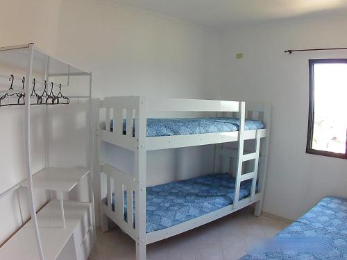 two white bunk beds in a room at AP Caraguatatuba - Indaiá in Caraguatatuba