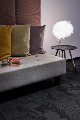 a couch with a lamp on a side table at Hotel Neuer Fritz in Berlin