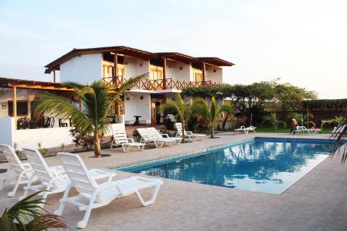 un complejo con piscina, sillas y una casa en Hotel Casa Vichayo, en Vichayito