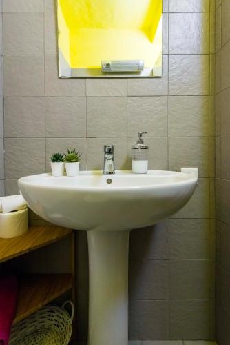 a white sink in a bathroom with a mirror at Elly's House in Modena