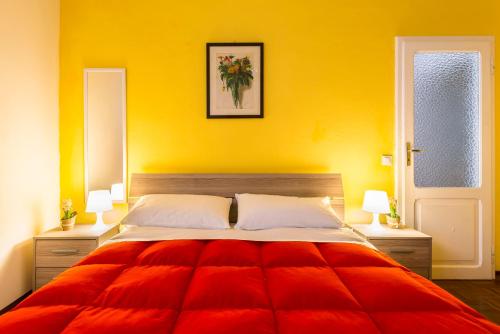 una camera da letto con un grande letto con una coperta rossa di Elly's House a Modena