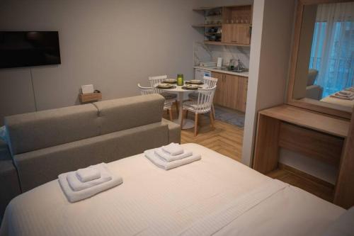 a room with a bed and a couch and a table at IRRESISTABLE STUDIO IN THE HEART OF XANTHI in Xanthi