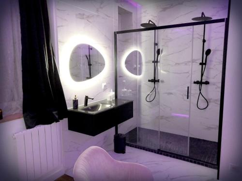y baño con lavabo y ducha con espejo. en Le Vénus - Appartement SPA Privatif Balnéo Sauna en Dijon