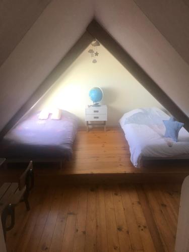 a bedroom with two beds in a attic at GITE de charme entre Terre et Mer "Wifi et Netflix" in Plougonven