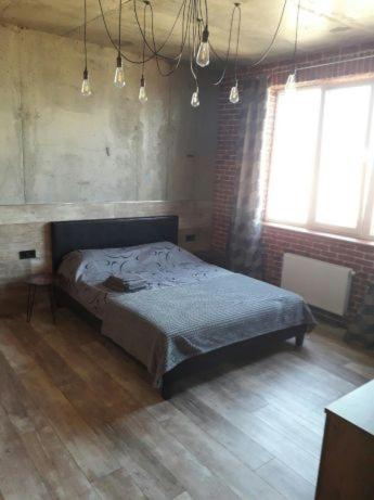 een slaapkamer met een bed in het midden van de kamer bij ОДНОКОМНАТНЫЙ ЛОФТ НА 26 ЭТАЖЕ in Odessa