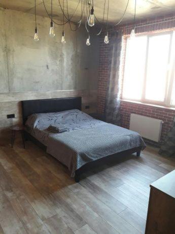 een slaapkamer met een bed en 2 ramen bij ОДНОКОМНАТНЫЙ ЛОФТ НА 26 ЭТАЖЕ in Odessa