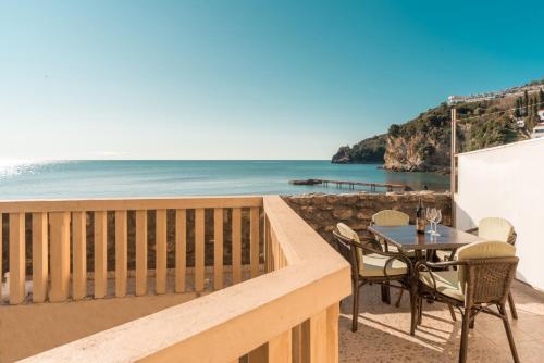 een balkon met een tafel en stoelen en de oceaan bij R club Apartments Old Town Budva in Budva