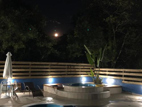 a patio with a hot tub and lights at night at João e Maria Restaurante e Chalés in Tiradentes