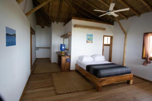 een slaapkamer met een bed en een plafondventilator bij Canoa Suites in Canoa