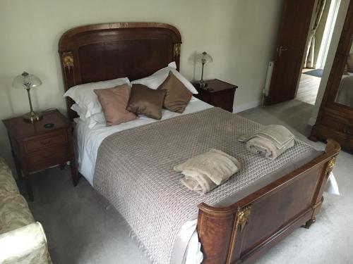 a bedroom with a large bed with two towels on it at Lemondrop Cottage in Southburgh