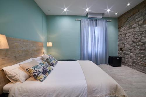 a bedroom with a large bed with a stone wall at AL22 di piazza del Gesù in Viterbo