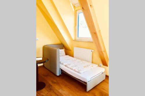 a small bed in a room with a window at SO APARTMENTS am Marktplatz 4 in Weinheim