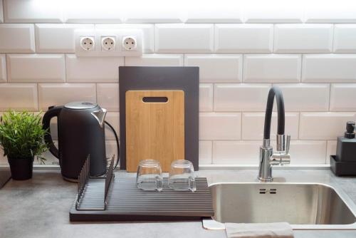 a kitchen sink with a drying rack next to a sink at Pintes 38 in Dunaújváros