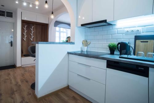 a kitchen with white cabinets and a blue counter top at Pintes 38 in Dunaújváros