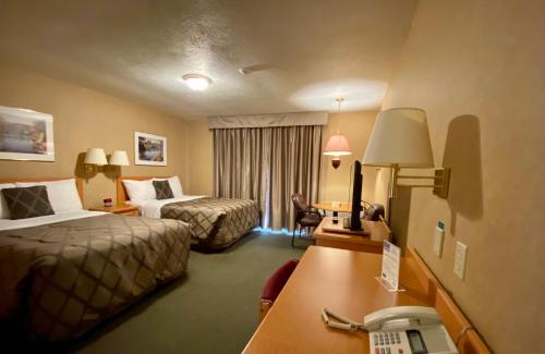 a hotel room with two beds and a desk at Country Inn Listowel in Listowel