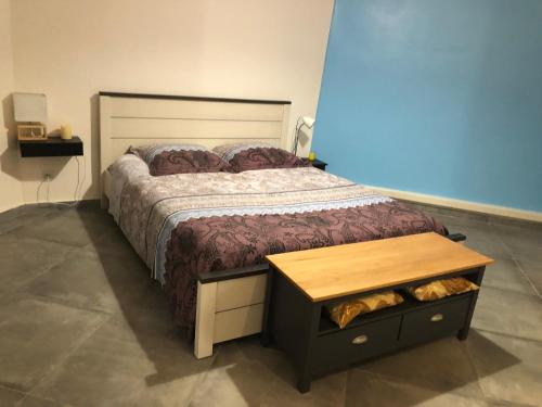- une chambre avec un grand lit et une table en bois dans l'établissement Belcourt, à Baie-Mahault