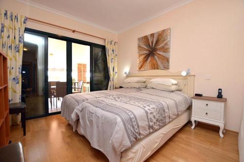 a bedroom with a bed and a large window at CONDOMINIO LOS OLIVOS DEL GOLF in Faro