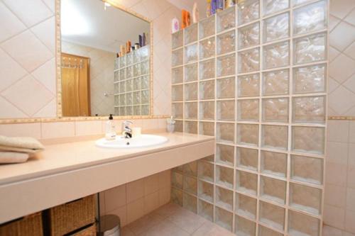 een badkamer met een wastafel en een spiegel bij CONDOMINIO LOS OLIVOS DEL GOLF in Faro