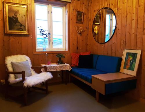 a living room with a blue couch and a chair at Drengestua på Flagstad Østre in Hamar