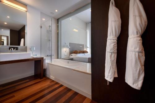 a bathroom with a tub and a large mirror at M'AR De AR Aqueduto in Évora